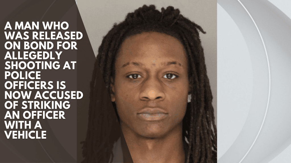 A man who was released on bond for allegedly shooting at police officers is now accused of striking an officer with a vehicle